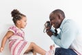 Young father with his cute little daughter taking pictures of each other on an old vintage camera Royalty Free Stock Photo