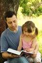 Young father with his little daughter reading the Bible Royalty Free Stock Photo