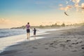 Young father and his son running with kite on the beach Royalty Free Stock Photo