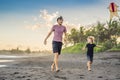 Young father and his son running with kite on the beach Royalty Free Stock Photo