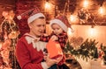 Young father and his son in Santa's hat open a Christmas gift present box. Winter holidays and childhood concept Royalty Free Stock Photo