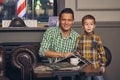 Young father and his stylish little son in the barbershop in the waiting room. Royalty Free Stock Photo