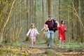 Young father and his three kids hiking in the woods. Family of four having fun on a walking trail on sunny spring day Royalty Free Stock Photo