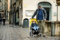 Young father and his toddler son in a stroller walking together down the medieval streets of Bergamo city northeast of Milan.