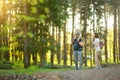 Young father and his two kids hiking in the woods. Family of three having fun on a walking trail on sunny spring day