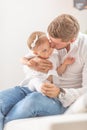 Young father holding and kissing his baby toddler girl on her cheek at home Royalty Free Stock Photo