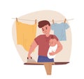 Young father holding newborn baby in arms and doing household chores. Dad ironing linen. Housekeeping and paternity