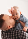 Young father holds in his arms and kisses his baby daughter on a white background Royalty Free Stock Photo