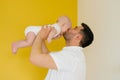 Young father holds his baby son in his arms, lifting him up and kissing him Royalty Free Stock Photo