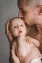 Young father holds his newborn son in a diaper in his arms and kisses him Royalty Free Stock Photo