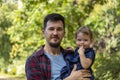 Young father holds little daughter in arms, a happy family. Caucasian man and little baby girl 1 year old Royalty Free Stock Photo