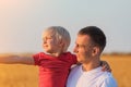 Young father holds son on hands and looks into distance. Paternal care and responsibility Royalty Free Stock Photo