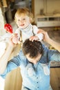 Young father at home giving his little son piggyback. Royalty Free Stock Photo