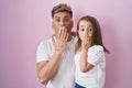 Young father hugging daughter over pink background covering mouth with hand, shocked and afraid for mistake Royalty Free Stock Photo