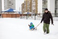 Young father and little boy enjoying sleigh ride. Child sledding. Toddler kid riding sledge. Children play outdoors in snow. Kids Royalty Free Stock Photo