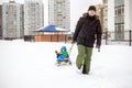 Young father and little boy enjoying sleigh ride. Child sledding. Toddler kid riding sledge. Children play outdoors in snow. Kids Royalty Free Stock Photo