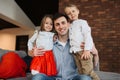 Young father with little children, daugter and son posing on sofa at home. Family time