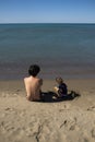 Young father and little daughter sitting on the beach and playing with sand Royalty Free Stock Photo