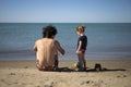 Young father and little daughter sitting on the beach and playing with sand Royalty Free Stock Photo