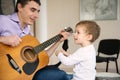 Young father and little son playing guitar Royalty Free Stock Photo