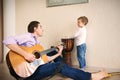 Young father and little son playing guitar Royalty Free Stock Photo