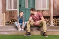 Young father with little son sitting on porch at backyard Royalty Free Stock Photo