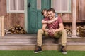 Young father with little son sitting on porch at backyard Royalty Free Stock Photo