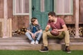 Young father with little son sitting on porch at backyard Royalty Free Stock Photo