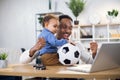 Young father and little son watching soccer match on laptop Royalty Free Stock Photo