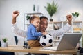 Young father and little son watching soccer match on laptop Royalty Free Stock Photo