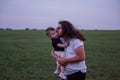 Young father with long hair, beard, glasses holds, kiss little son, who playfully raises his arm Royalty Free Stock Photo