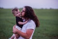 Young father with long hair, beard, glasses holds, kiss little son, who playfully raises his arm Royalty Free Stock Photo