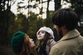 Young father, mother and little toddler daughter girl in a beret and a coat walk holding hands in the autumn forest. Royalty Free Stock Photo