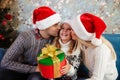 Young father and mother in Santa`s hat kissing those little daug Royalty Free Stock Photo