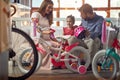 Young father and mother shopping new bicycle for little child in bike shop Royalty Free Stock Photo