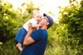 Young father in nature holding baby son in the arms. Royalty Free Stock Photo