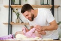 Young man play with his laying baby girl. Royalty Free Stock Photo