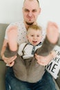 A young father playing with his funny little son and holding his legs Royalty Free Stock Photo