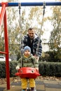 Young father playing with his little son on the playground in autumn park Royalty Free Stock Photo