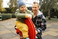 Young father playing with his little son on the playground in autumn park Royalty Free Stock Photo