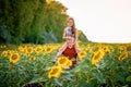 A young father plays with his daughter in a field of sunflowers. A little girl sits on her father`s neck and laughs. Family summer