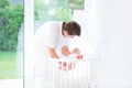 Young father putting his newborn baby in crib Royalty Free Stock Photo