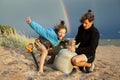 Young father with son on beach digging pit under the rainbow, playing, looking for treasure, lifestyle happy family on