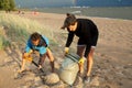 Young father with son on beach digging pit under the rainbow, playing, looking for treasure, lifestyle happy family on