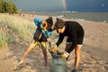 Young father with son on beach digging pit under the rainbow, playing, looking for treasure, lifestyle happy family on