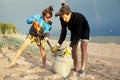 Young father with son on beach digging pit under the rainbow, playing, looking for treasure, lifestyle happy family on