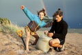 Young father with son on beach digging pit under the rainbow, playing, looking for treasure, lifestyle happy family on