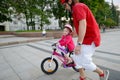 Young father teaching his daughter to ride a bike Royalty Free Stock Photo