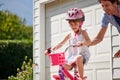 Teaching her independent skills. a young father teaching his daughter to ride a bike. Royalty Free Stock Photo