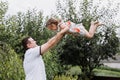 Young father throwing his baby daughter high in the sky in the park in summer day. father`s day Royalty Free Stock Photo